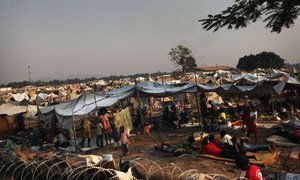 Displaced children and adults shelter outside a barbed-wire fence, in a camp set up behind Mpoko International Airport in Bangui, Central African Republic (CAR).