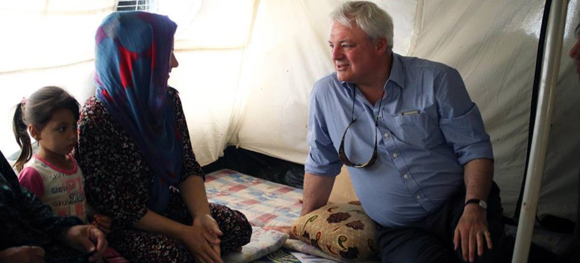 Humanitarian chief Stephen O’Brien speaks to a family in the Baharka IDP camp, during a two day visit to Iraq in June 2015.
