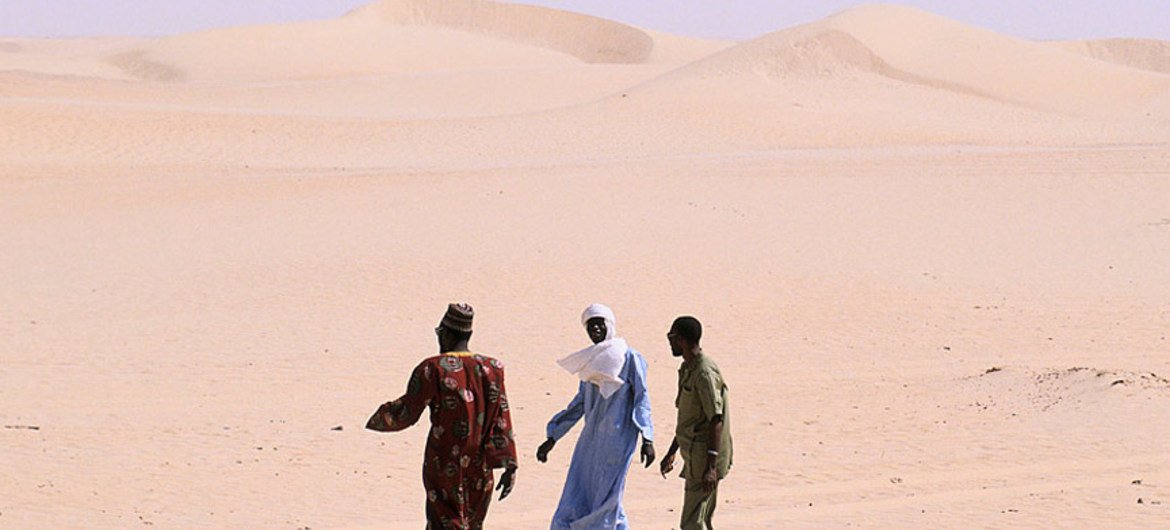 Des personnes marchant dans le désert.