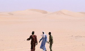Des personnes marchant dans le désert.