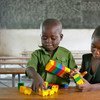 طفلان يلعبان في مدرسة ابتدائية، في زيمبابوي. من صور اليونيسف / جياكومو بيروزي