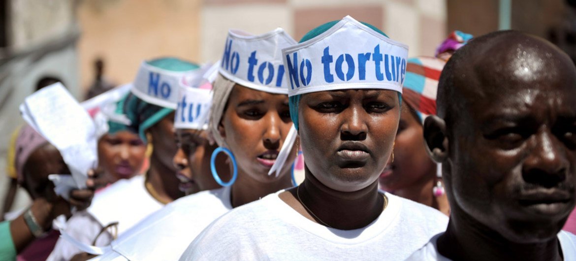 Singers wearing hats advocating “No Torture” line up before performing at a Human Rights Day event outside of Mogadishu Central Prison in Somalia.