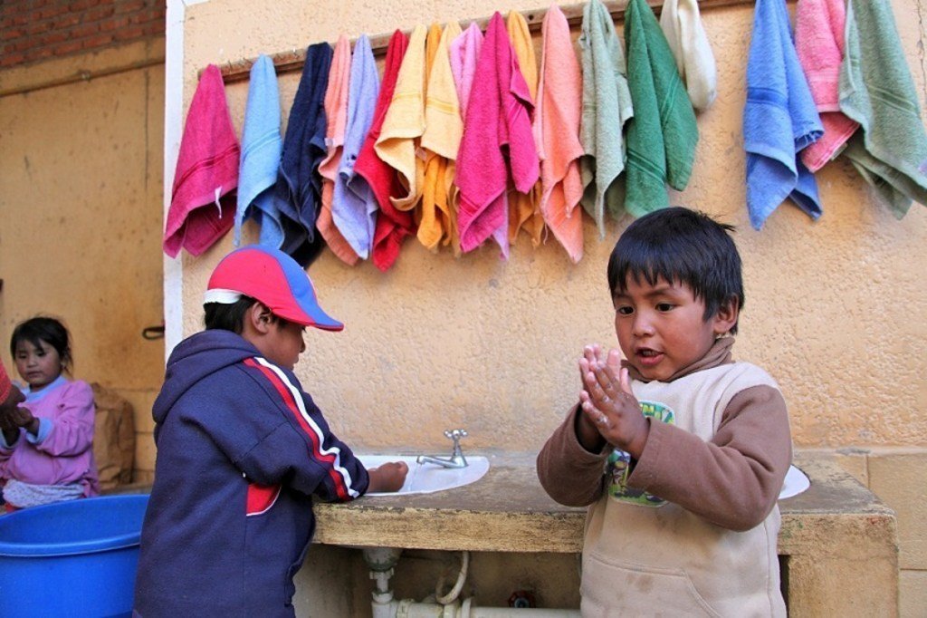 طفلان يقومان بغسل أياديهما بالصابون في محطة لغسل اليدين  في مركز تنمية الطفولة المبكرة  في سوكري، بوليفيا. من صور: اليونيسف / NYHQ2013-1499 / بيروزي