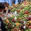 一名顾客在巴塞罗那的市场挑选水果。