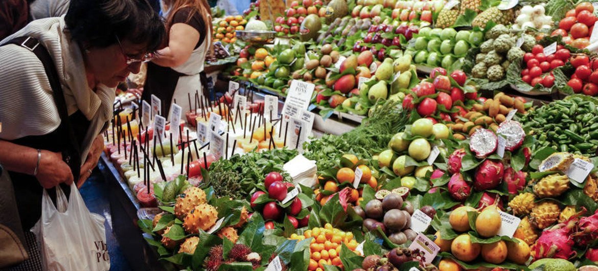 一名顾客在巴塞罗那的市场挑选水果。图片来源：粮农组织