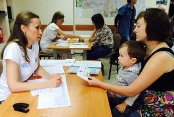 A mother and son receiving a WFP food voucher, distributed by NGO partner, ADRA, in Sloviansk, Ukraine.