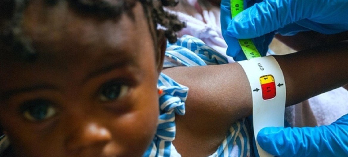A baby girl's arm is measured by a health worker at the UNICEF-supported Pipeline Health Centre in Liberia, Monrovia (January 2015).