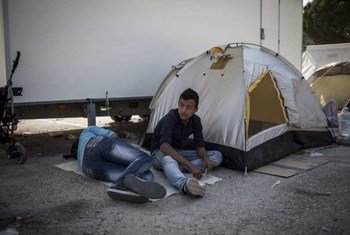 Two boys rest next to their tent outside the screening centre at Moria. Refugees and migrants live in tents until there is space available to accommodate them inside the centre.