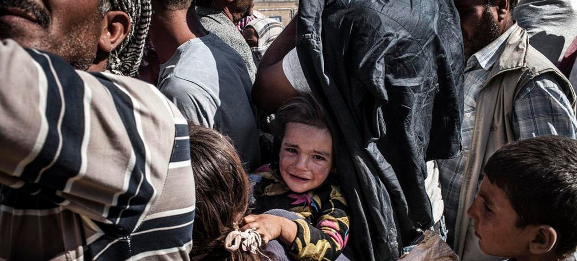 Des réfugiés syriens fuyant les combats près de la ville syrienne de Kobané attendent d'embarquer dans des bus vers la Turquie (septembre 2014). Photo : UNHCR / I. Prickett