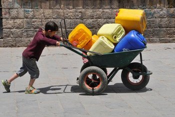 A boy pushes a wheelbarrow filled with jerrycans in Sanaa, the Yemeni, capital.