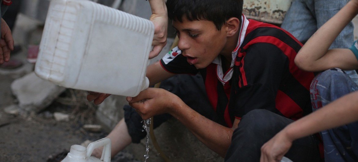 Ребенок  пьет остатки  воды  в сирийском городе Дума  Фото ЮНИСЕФ
