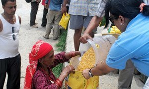 A woman receives lentil seeds in Nepal.