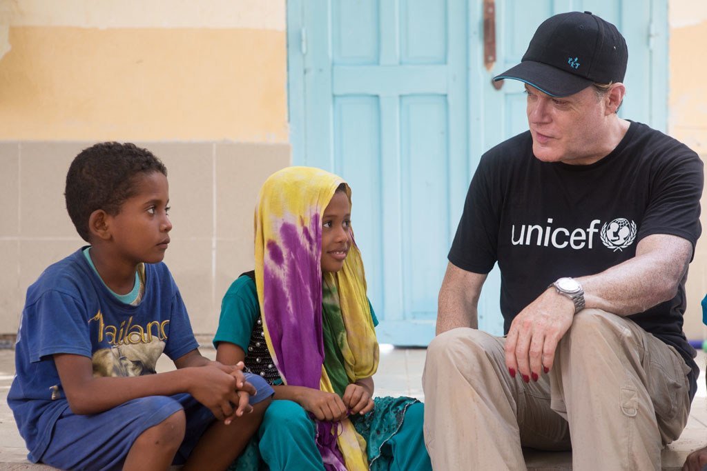 UNICEF UK Ambassador Eddie Izzard with Jawaher and her brother Ziad, at Caritas Educaction Centre, in Obock, Djibouti.