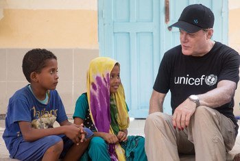 UNICEF UK Ambassador Eddie Izzard with Jawaher and her brother Ziad, at Caritas Educaction Centre, in Obock, Djibouti.