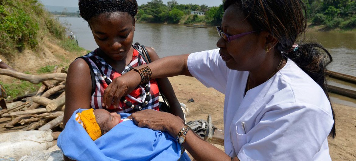 In the Central African Republic (CAR), a nurse vaccinates a baby in a village along the Oubangui River, which divides CAR from the Democratic Republic of Congo (DRC).