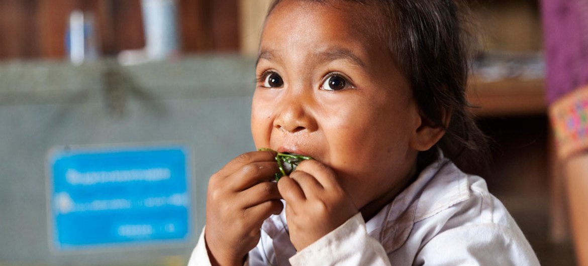 老挝乌多姆赛省（Oudomxay），一名儿童正在进食蔬菜。老挝的全国校园膳食计划至少为在校儿童提供了每日所需营养和能量的三分之一。