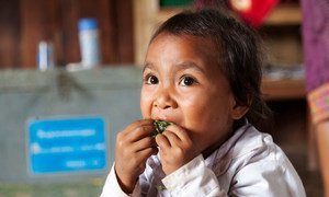 Through a national school feeding program in Oudomxay province, Lao PDR, students get at least a third of their daily energy and nutrition needs. Seen here, a student enjoys her vegetables.