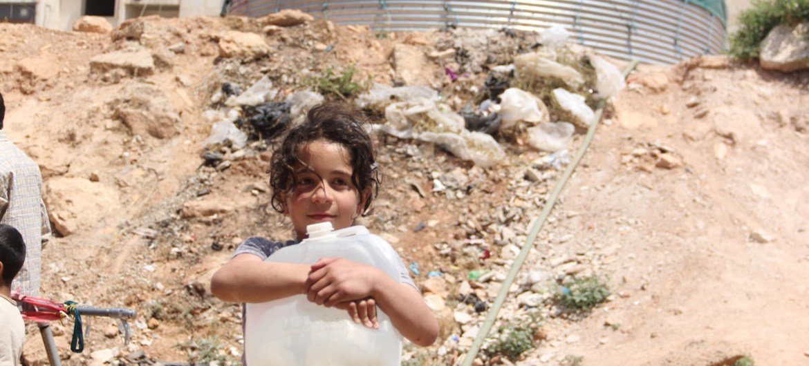 فتاة تحمل وعاء بلاستيكي للمياه في مخيم تشرين للنازحين في حلب، سوريا. من صور: اليونسف / رزان رشيدي