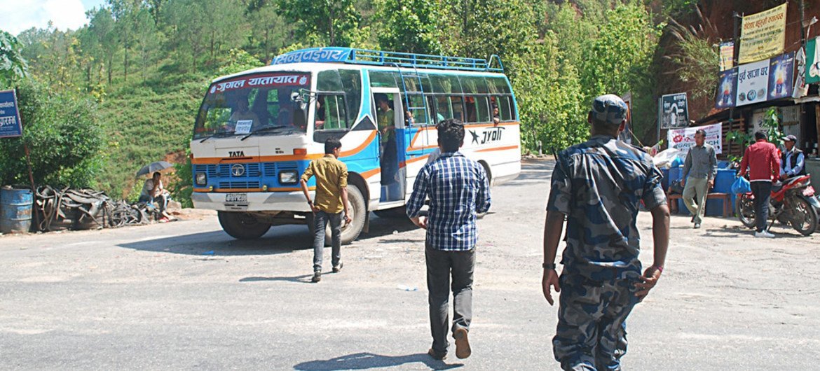 At the Bandeu checkpoint in Nepal, inspectors and a police constable approach a bus to look for potential victims of child trafficking onboard.