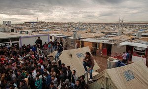 Syrian refugees crowd around an office in Domiz refugee camp in the Kurdistan Region of Iraq.