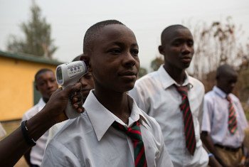 A boy’s temperature is taken as he arrives at school in Kenema, Sierra Leone (March 2015). Temperature screening is part safety protocols in schools across the country to minimize the risk of Ebola transmission.