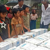 Children in Myanmar wait during distribution of household items for people affected by Cyclone Komen, in Ka Ye Nyaing, Maungdaw township, Rakhine State.