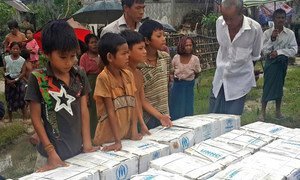Children in Myanmar wait during distribution of household items for people affected by Cyclone Komen, in Ka Ye Nyaing, Maungdaw township, Rakhine State.