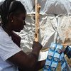 موظفة صحة في جنوب السودان تحمل أكياس تنقية المياه لتوزيعها على المرضى عند خروجهم من وحدة لعلاج الكوليرا، كجزء من الجهود المتضافرة لاحتواء انتشار المرض. الصورة: منظمة الصحة العالمية / ماتيلدا مويو