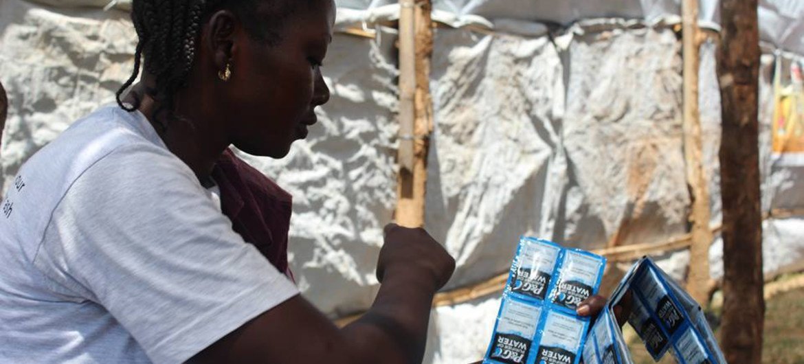 موظفة صحة في جنوب السودان تحمل أكياس تنقية المياه لتوزيعها على المرضى عند خروجهم من وحدة لعلاج الكوليرا، كجزء من الجهود المتضافرة لاحتواء انتشار المرض. الصورة: منظمة الصحة العالمية / ماتيلدا مويو