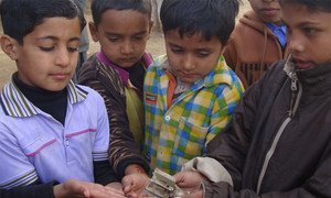 Pakistani children hold the remains of a shell that fell during clashes with India in Kashmir. Photo: Sumaira Jajja/IRIN (file)