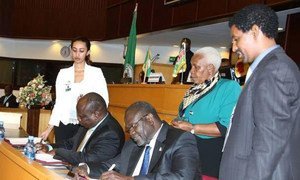Former South Sudan Vice President Riek Machar (seated right) and Pagan Amum Okiech, representing the Former Detainees, sign the compromise peace agreement put forth by the Intergovernmental Authority on Development Partners Forum (IGAD) mediation in Addis Ababa, Ethiopia.