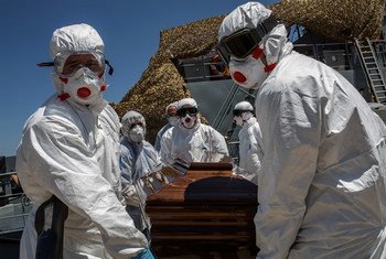Des opérateurs locaux spécialisés transportent le cercueil d'un migrant mort noyé au large des côtes libyennes (archive)