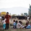 Migrants and asylum-seekers, mostly Syrian Kurds, sit in the yard outside a schoolhouse-turned-reception centre, known as Vrazhdebna, on the outskirts of the Bulgarian capital Sofia.