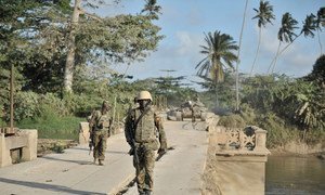 Ugandan soldiers serving with the African Union Mission in Somalia (AMISOM), walk across a bridge near the town of Janaale, Somalia.