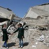 Школьницы  держатся за  руки, стоя во  дворе  разрушенной  школы в  секторе  Газа. Фото ЮНИСЕФ