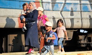 一家移徙者正准备登上前往希腊的火车。他们的目的地是德国。联合国儿基会/NYHQ2015-2083/Georgiev