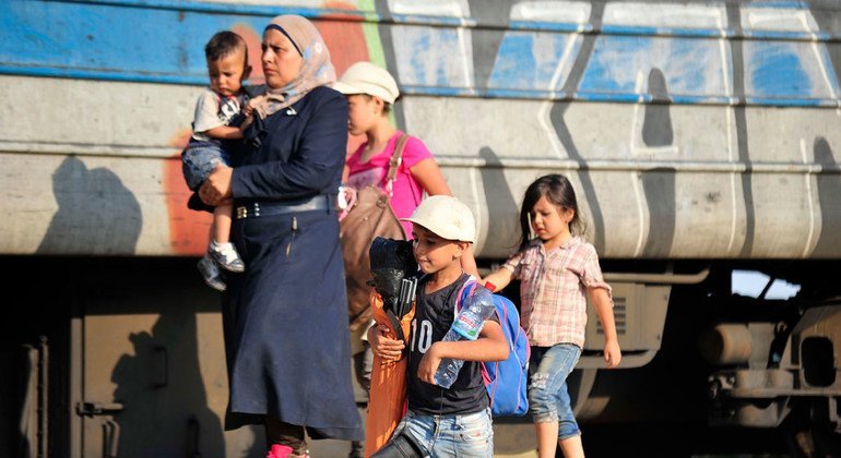 Una mujer carga a sus nietos en la frontera entre Grecia y la ex República Yugoslava de Macedonia. Esperan abordar un tren rumbo a Alemania. Foto: UNICEF/NYHQ2015-2083/Georgiev.
