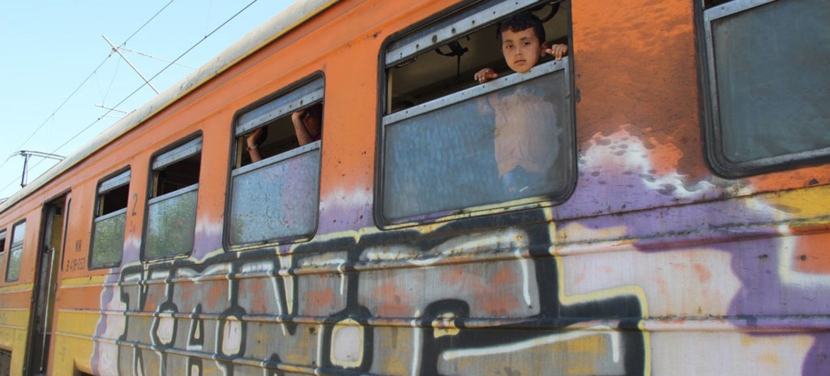 A child looks out of the window of a train near Gevgelija, in the Former Yugoslav Republic of Macedonia. Families seeking refuge from conflict in their homelands are traveling by train from Gevgelija to the border with Serbia, after crossing the border wi