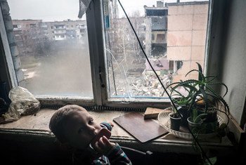 Nikita, 5 ans, dont le père a été tué en rentrant du travail dans un bombardement, regarde par la fenêtre dans un quartier de la ville de Pervomaysk à Donetsk Oblast (décembre 2014). Photo : © UNICEF / NYHQ2014-3507 / Volpi