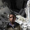 在叙利亚城市阿勒坡，一名男孩站住一栋被毁的建筑前。人道协调厅图片/Gemma Connell