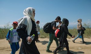 A group of people walking on a dirt road near the town of Gevgelija in the former Yugoslav Republic of Macedonia, after crossing the border at Idomeni in Greece.