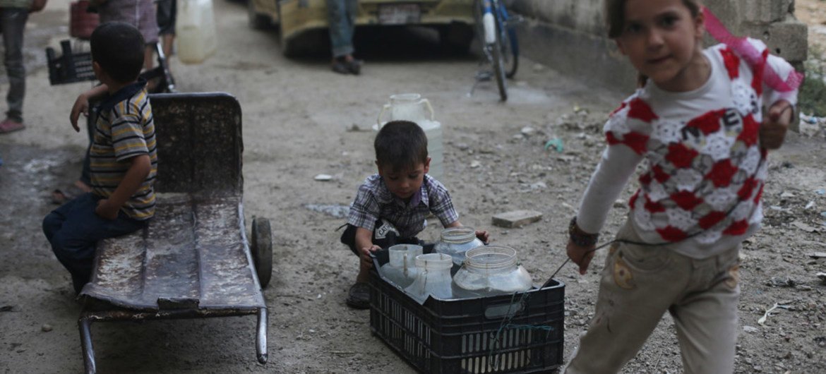 أطفال  ينقلون المياه في بلدة دوما في منطقة الشرق الغوطة في ريف دمشق، سوريا. المصدر: اليونيسف / بسام خابية