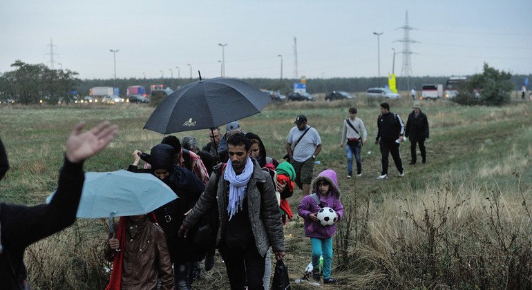 Refugiados sirios cruzan un descampado entre Hungría y Austria. Foto: ACNUR/Mark Henley