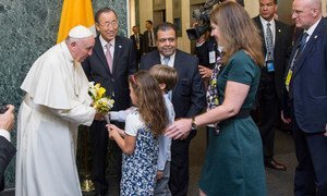 Pope Francis is welcomed by Secretary-General Ban Ki-moon and receives flower bouquets from children of UN staff members at the start of his visit to UN  Headquarters.