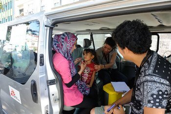 Medical personnel from Médecins Sans Frontières assess the health of a girl, who is accompanied by her mother, in Belgrade, the capital of Serbia.