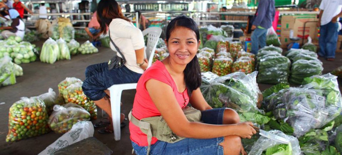 Une adolescente vend de la laitue sur un marché de légumes à La Trinidad, province de Benguet, aux Philippines. Les jeunes ruraux représentent une portion significative de la force de travail agricole et peuvent jouer un rôle majeur dans le développement 
