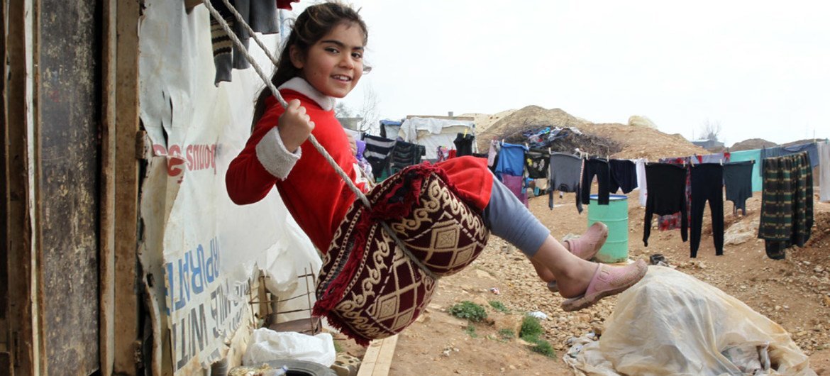 A girl plays on a swing, in the Faida informal tented settlement for Syrian refugees, in Lebanon’s Bekaa Valley.