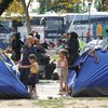 مجموعة من الأطفال والنساء والرجال اللاجئين، خارج  خيام  صغيرة في حديقة بالقرب من محطات الحافلات والقطارات في بلغراد، العاصمة الصربية. المصدر: اليونيسف / شوبكل