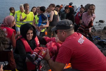Des volontaires aides des réfugiés à débarquer d'un bateau sur l'île grecque de Lesbos. Photo UNICEF/Ashley Gilbertson VII