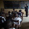 A teacher leads students during a sing-along in a class at Monrovia Demonstration School in Liberia.